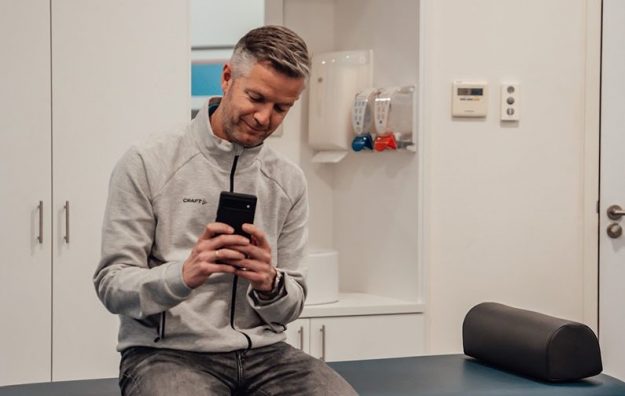 Man werkt met smartphone en voorkomt nekpijn