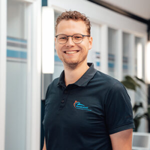 Bob Verweij Profielfoto van Bob Verweij die als fysiotherapeut poseert voor de camera in een grijze hoodie en blauwe polo