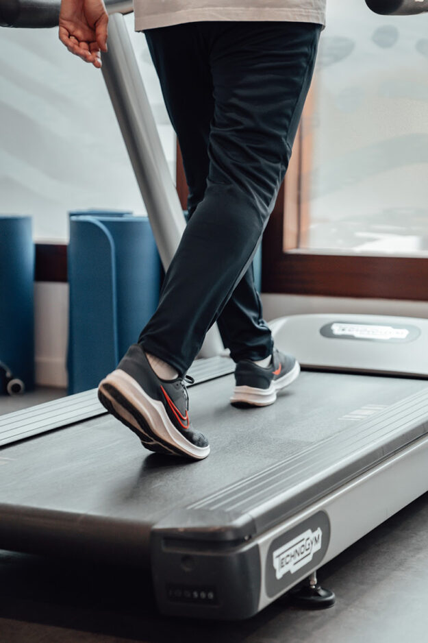 persoon loopt op de loopband om scheenbeenklachten te voorkomen