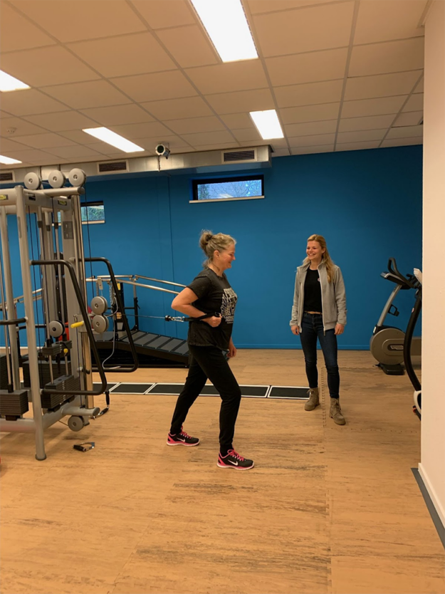 Jennie voert oefeningen uit in de oefenzaal onder begeleiding van fysiotherapeut Manon voor haar revalidatietraject na een heupoperatie.