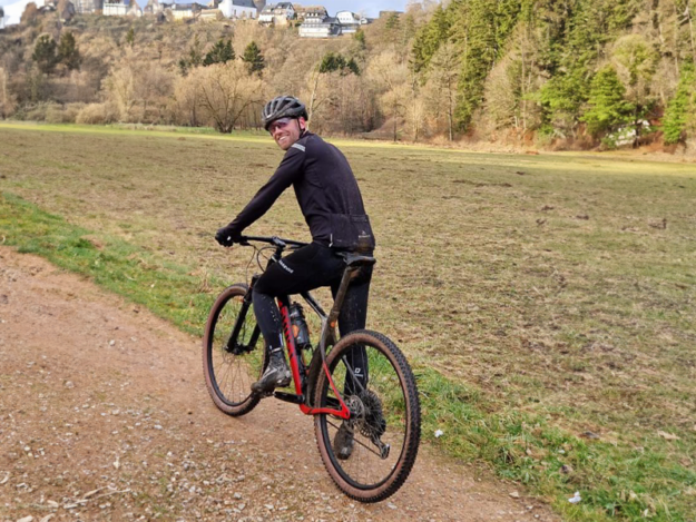 Duursporter op de fiets en in sportkleding werkt aan zijn coördinatie en mobiliteit door middel van Endurance Support.