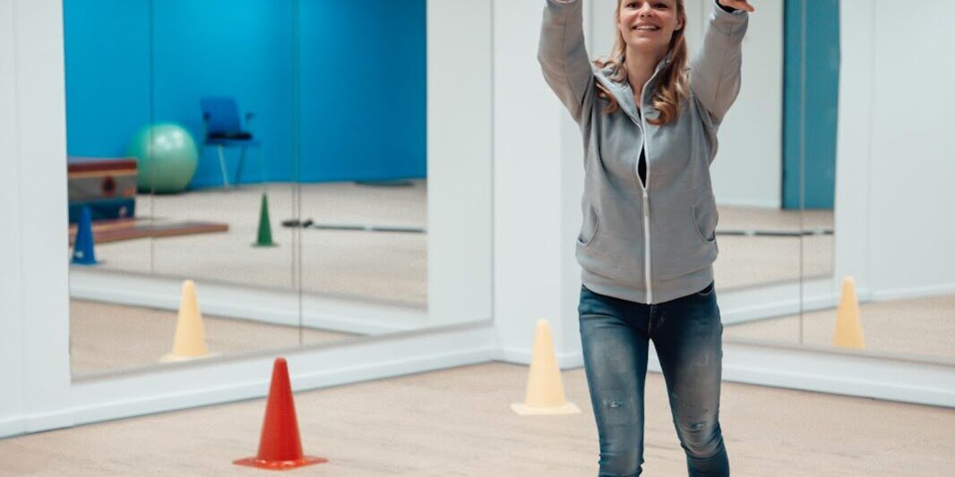 Bewegen Een vrouw is aan het bewegen. Ze staat in een oefenzaal en ze gooit een bal omhoog.