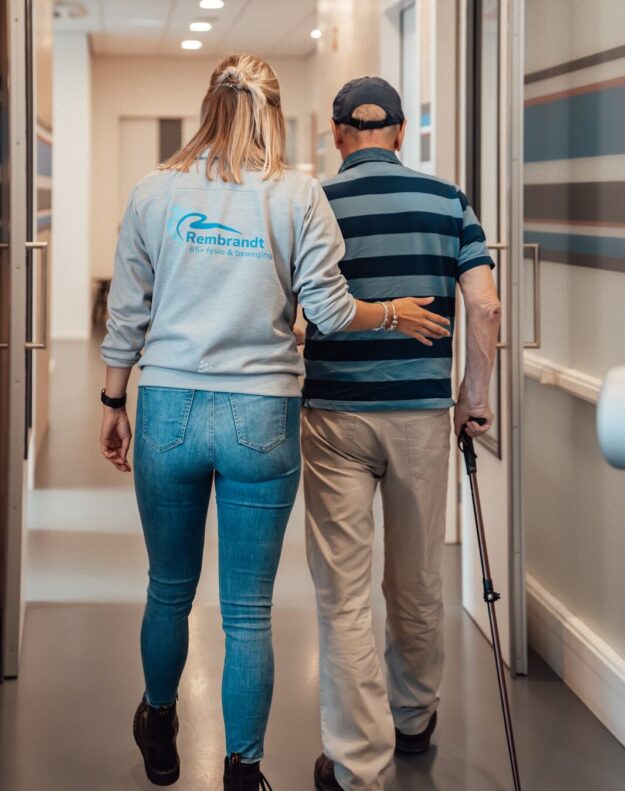 Mevrouw is met oudere man aan het lopen om verminderen van valrisico’s bij ouderen