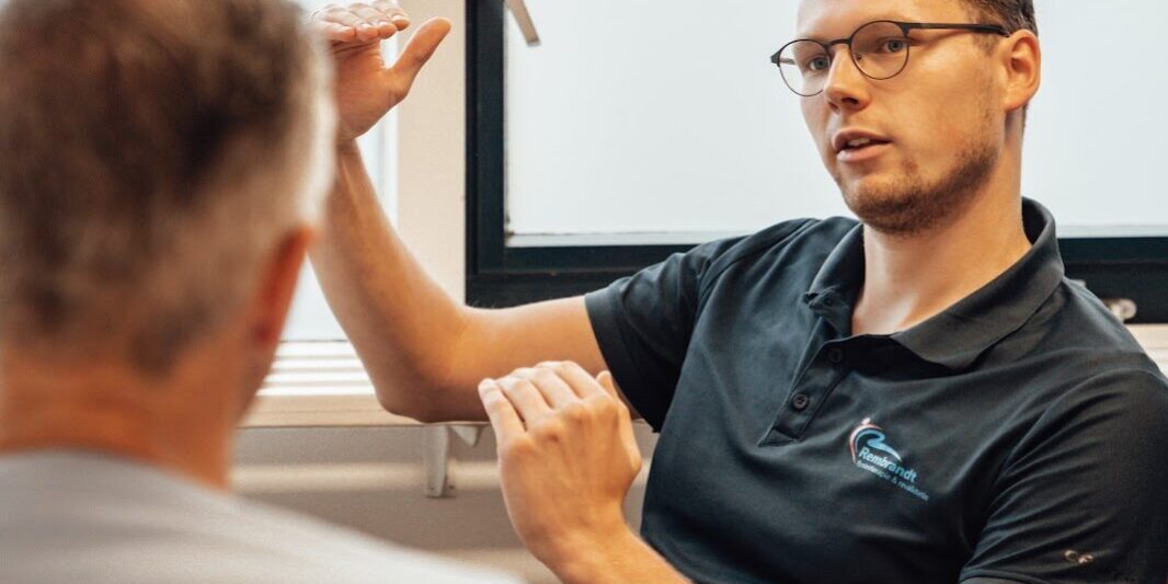 Ischias Therapeut geeft uitleg aan een man over ischias