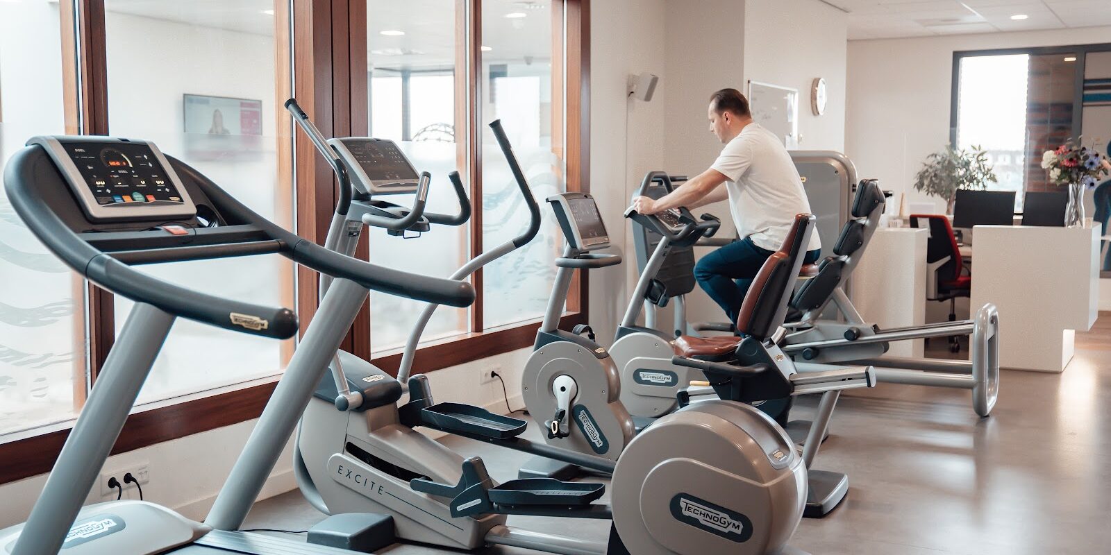 een man op een fitness apparaat om zijn cardio te doen ter voorbereiding van zijn training als krachtige warming-up voor astma