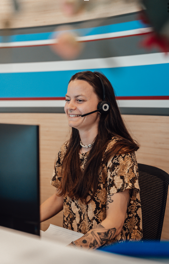 vrouw die achter de computer zit met headset op