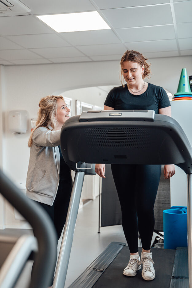 Vrouw wordt geholpen door de fysiothearpeut bij hardloopblessures