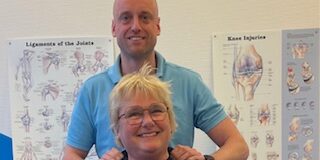 Annemarie en Roel Een fysiotherpeut samen met een patiënt in een behandelkamer