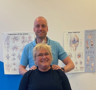 Annemarie en Roel Een fysiotherpeut samen met een patiënt in een behandelkamer