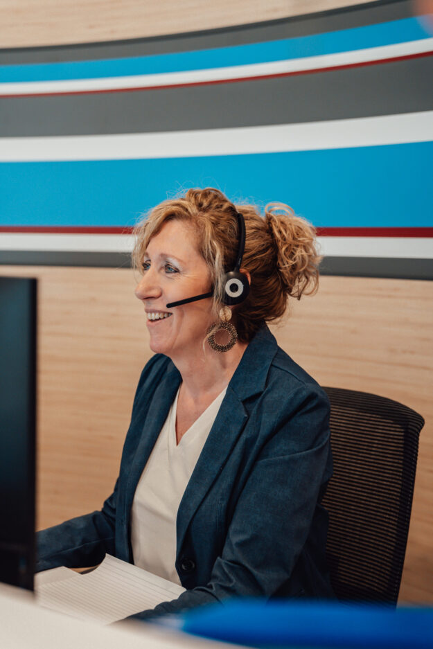 Collega Nancy met headset achter computer